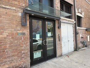 A brick building with a glass storefront and a metal awning.