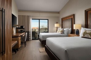 A hotel room with two beds, a desk, a chair, a TV, and a balcony with a view. - Marriott Plaza Santonio (San Antonio)