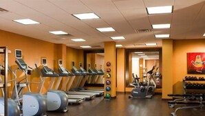 A gym with treadmills, elliptical machines, and exercise balls.