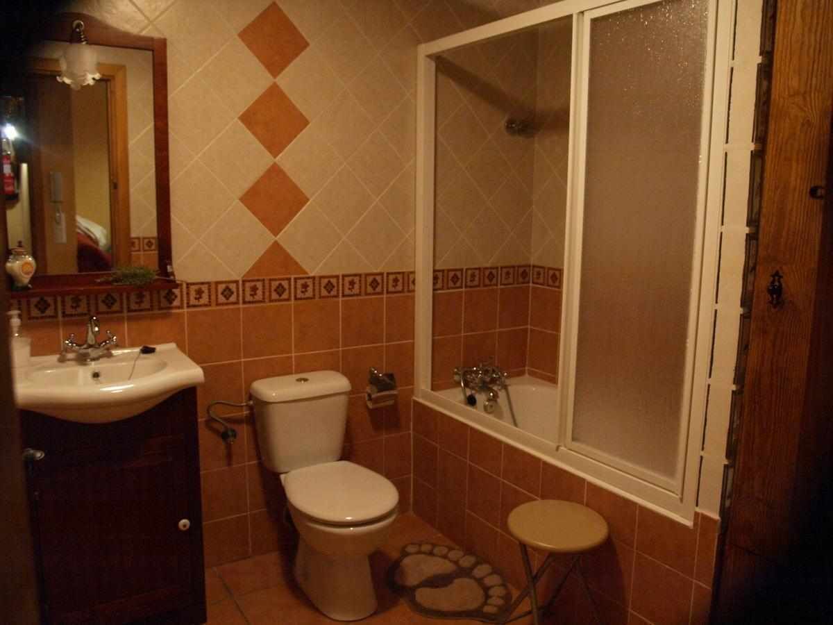 A small bathroom with a toilet, sink, and a shower area.