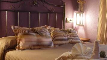 Ein Bett mit gestreiften Kissen, einem Kopfteil und einem Nachttisch mit Lampe.