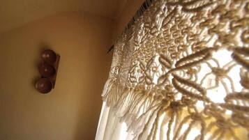 A close-up of a textured fabric with a fringe detail, possibly part of a room's decor.
