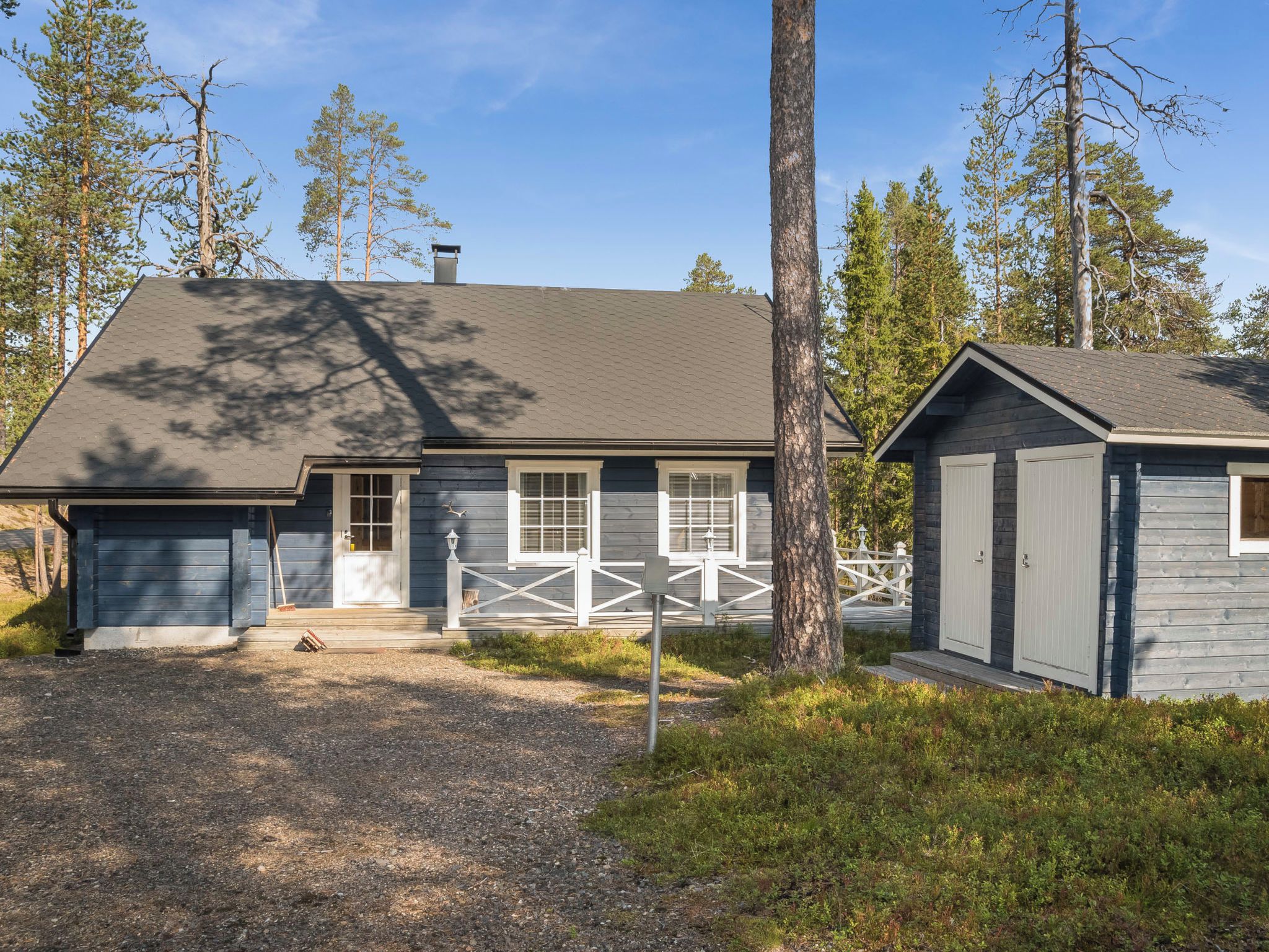 A two-story house with a front porch, a garage, and a fenced yard.
