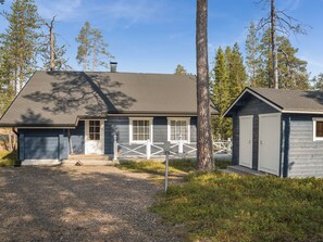 A two-story house with a front porch, a garage, and a fenced yard. - Koskelo by Interhome (Äkäslompolo)
