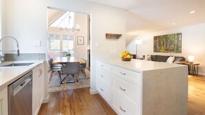 A modern kitchen with a dining area, wooden flooring, and a large island. - Luxury 3BR/2BA-1700 sq ft, Mountain view,BBQ (Whistler)