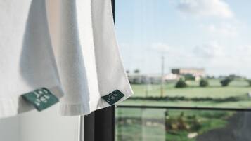 Una ventana con vistas a un paisaje verde y un edificio a lo lejos.