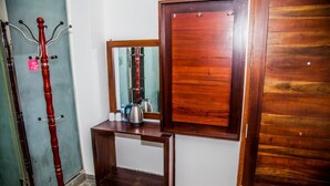 Ein Holztisch mit einem Spiegel, einem Wasserkocher und einer Wasserflasche.