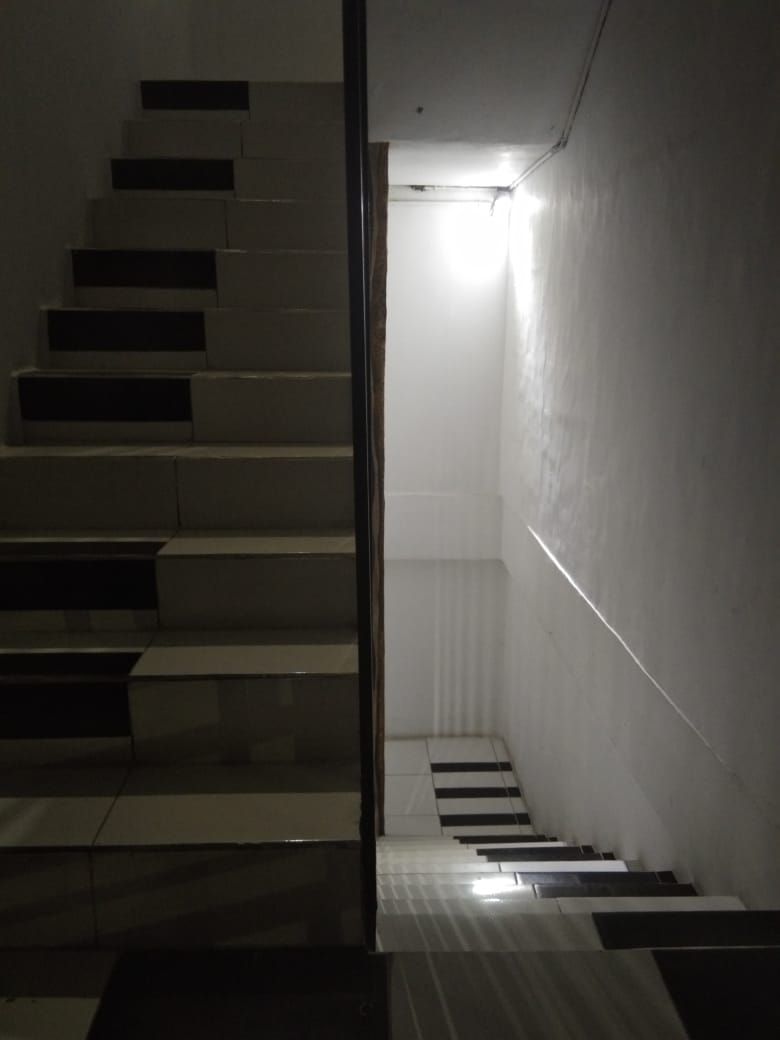 A staircase with a light source at the top, leading to a landing.