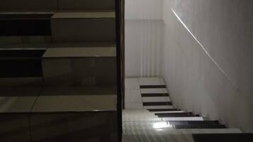 A staircase with a light source at the top, leading to a landing.