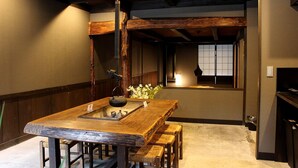 Ein traditioneller japanischer Raum mit Holztisch, Tatami-Matten und Shoji-Schirm.
