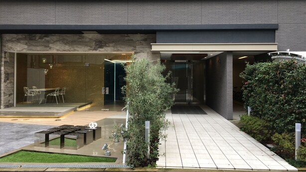 A modern building with a glass entrance, outdoor seating, and a small garden area. - 7mins Shinsaibashi Comfortable Apartment (Osaka)