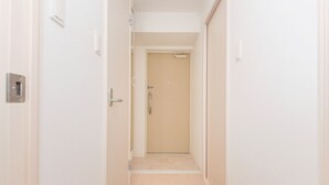A narrow hallway with a door at the end leading to a room. - 7mins Shinsaibashi Comfortable Apartment (Osaka)
