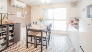A kitchen with a dining table, chairs, and a refrigerator. - Sakuragawa no Shima (Osaka)