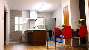 Eine moderne Küche mit Kochinsel, roten Stühlen und einem Kühlschrank.