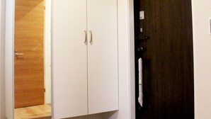 Ein Zimmer mit einem weißen Kleiderschrank, einer Holztür und einer roten Fußmatte am Eingang.