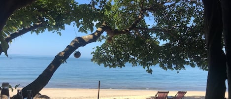 En la playa, sombrillas, masajes en la playa y vóleibol de playa 