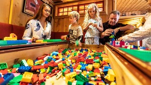 Un intérieur en bois avec un grand espace de jeux rempli de blocs de construction colorés.
