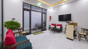 A modern lobby with a seating area, a reception desk, and a large window. - Onion Homestay (Da Nang)