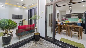 A modern living room with a sofa, a coffee table, and a potted plant. - Onion Homestay (Da Nang)