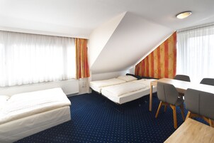 A hotel room with a bed, a desk, and a chair.