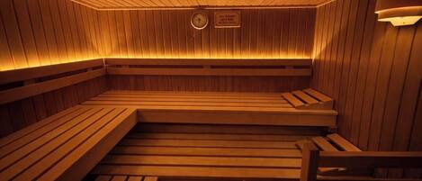 Eine Sauna mit Holzbänken und einer an der Wand befestigten Uhr.