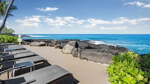 Eine Strandlounge mit Liegestühlen und Blick auf den Ozean.