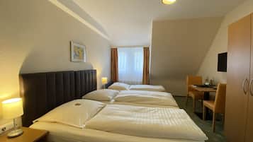 Una habitación de hotel con una cama grande, un escritorio y una silla.