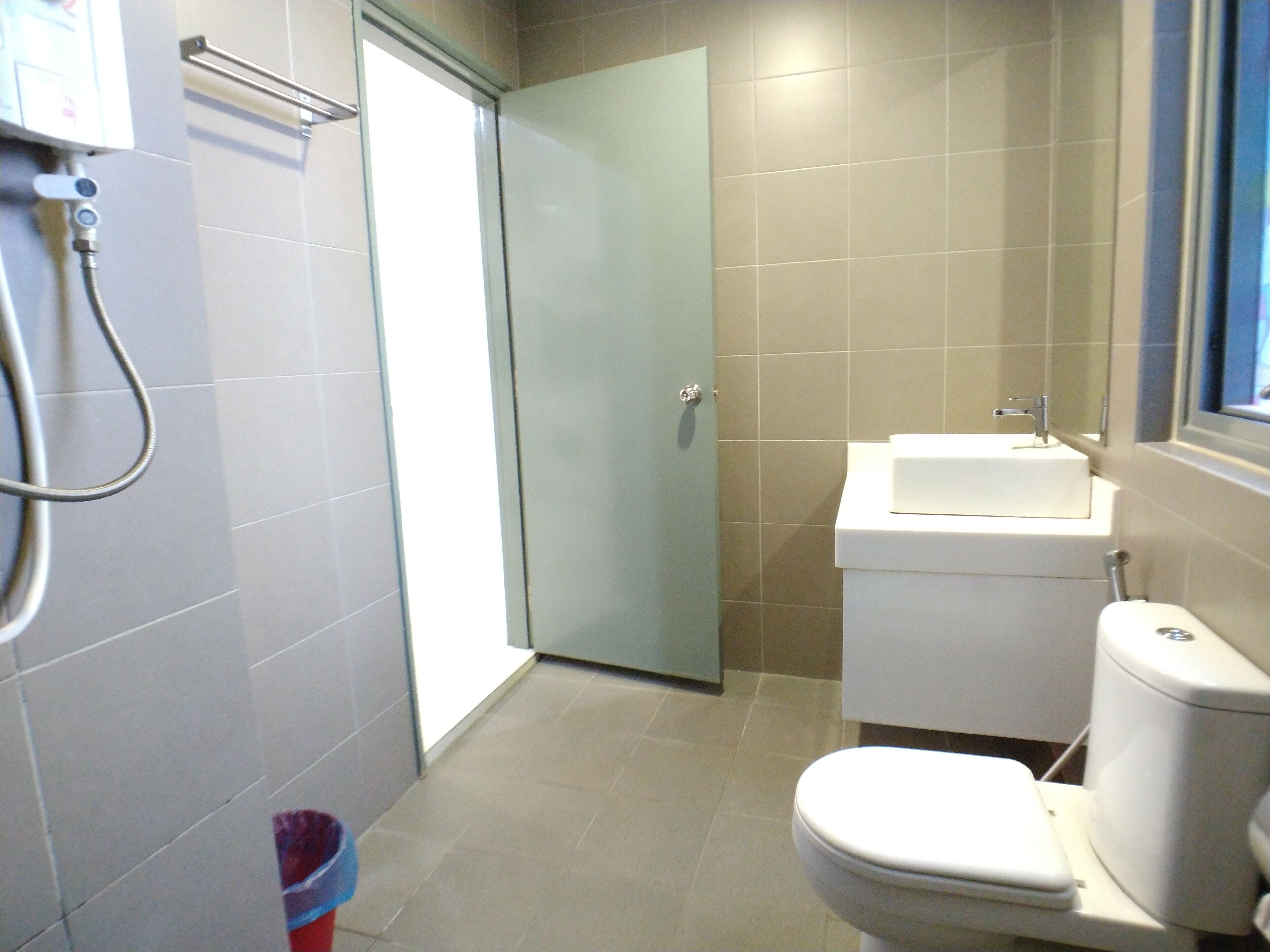 A bathroom with a toilet, sink, and shower.