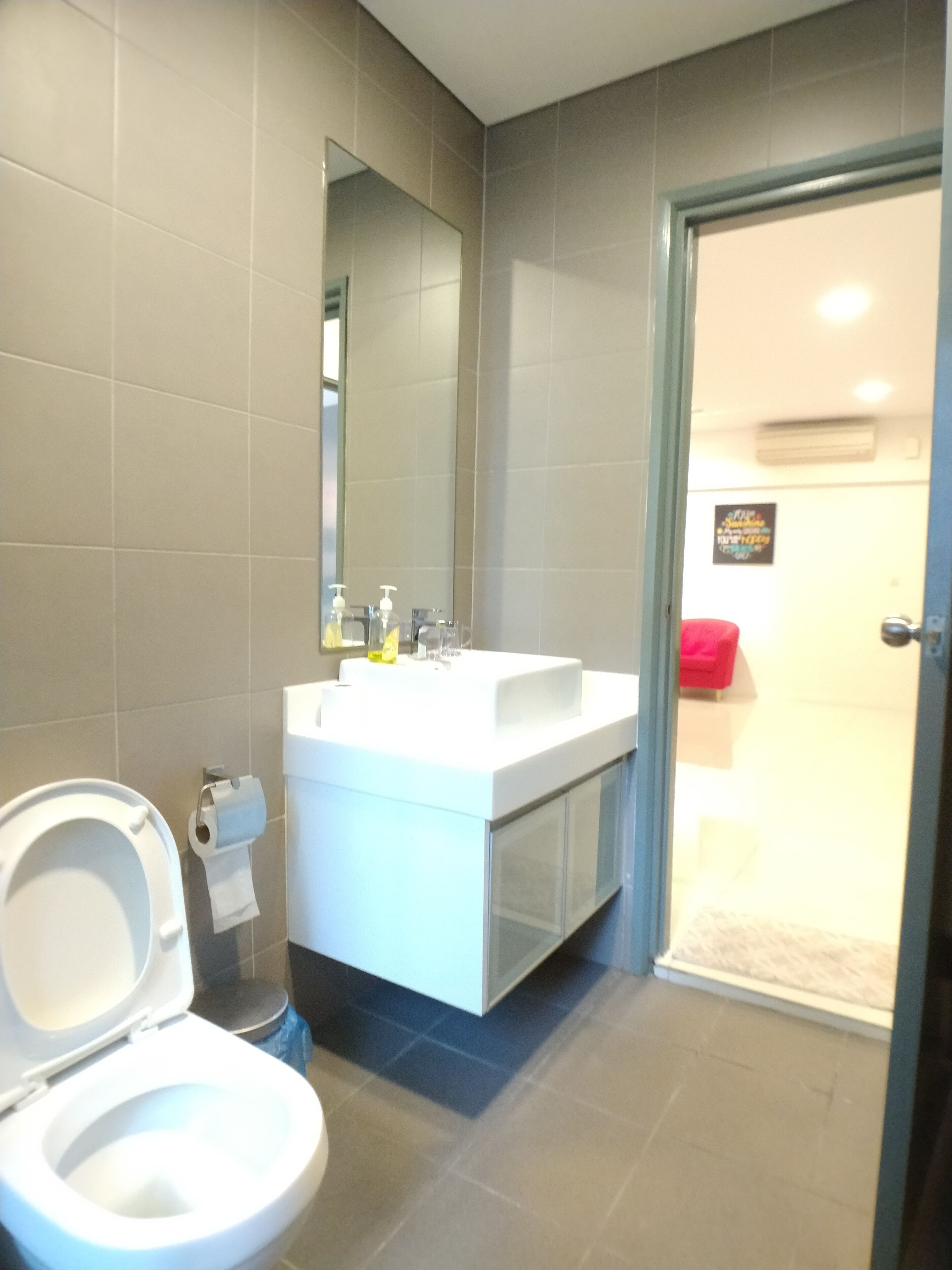 A modern bathroom with a toilet, sink, and mirror.