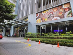 A building with a cafe-in-house sign, large windows, and a modern architectural design. - OHO Suites KLCC Summer Suites (Kuala Lumpur)