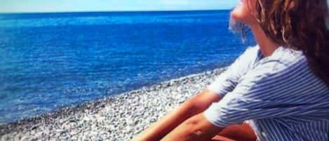 On the beach, black sand, beach cabanas, sun-loungers