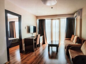 Deluxe suite | Woonkamer | Flatscreentelevisie