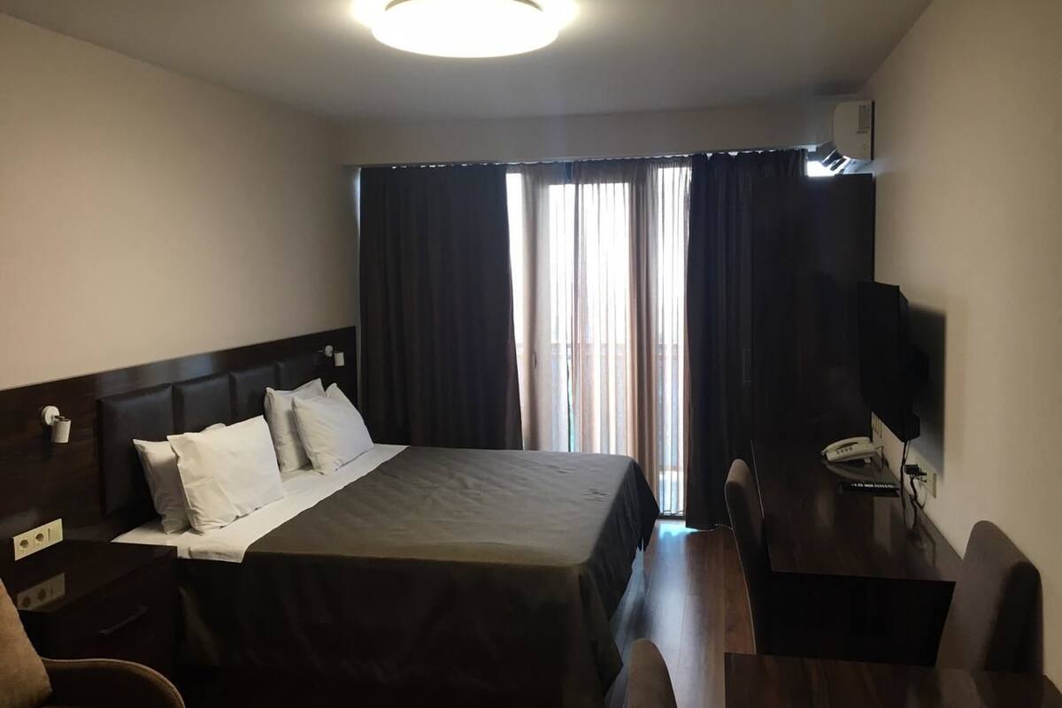 Premium bedding, desk, laptop workspace, blackout drapes