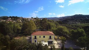 A yellow building with a red roof surrounded by greenery and hills. - Lamione da Dorotea (Torchiara)