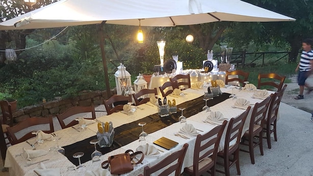 A long dining table set outdoors with chairs, white tablecloths, and candles. - Lamione da Dorotea (Torchiara)