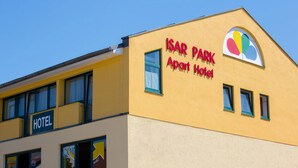 Ein Gebäude mit der Aufschrift „ISAR PARK Apart Hotel“ und einem Logo darüber.