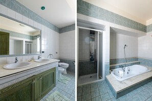 A bathroom with two sinks, a toilet, and a shower area.
