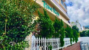 A hotel with a sign reading "Hotel de Luxe" and a white decorative fence. - Hotel Time Rich (Okinawa)