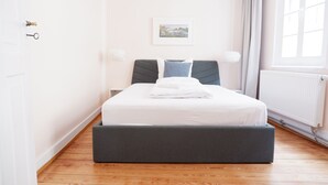 A bedroom with a bed, a window, a radiator, and a door. - 3-Zimmer Apartment mit 2 Bädern am Marktplatz (Tuebingen)