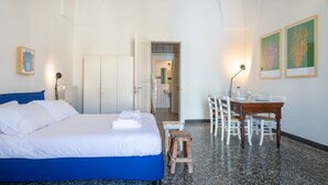A hotel room with a bed, a desk, chairs, and a small table. - Italianway - Sant'Oronzo Apartment (Lecce)