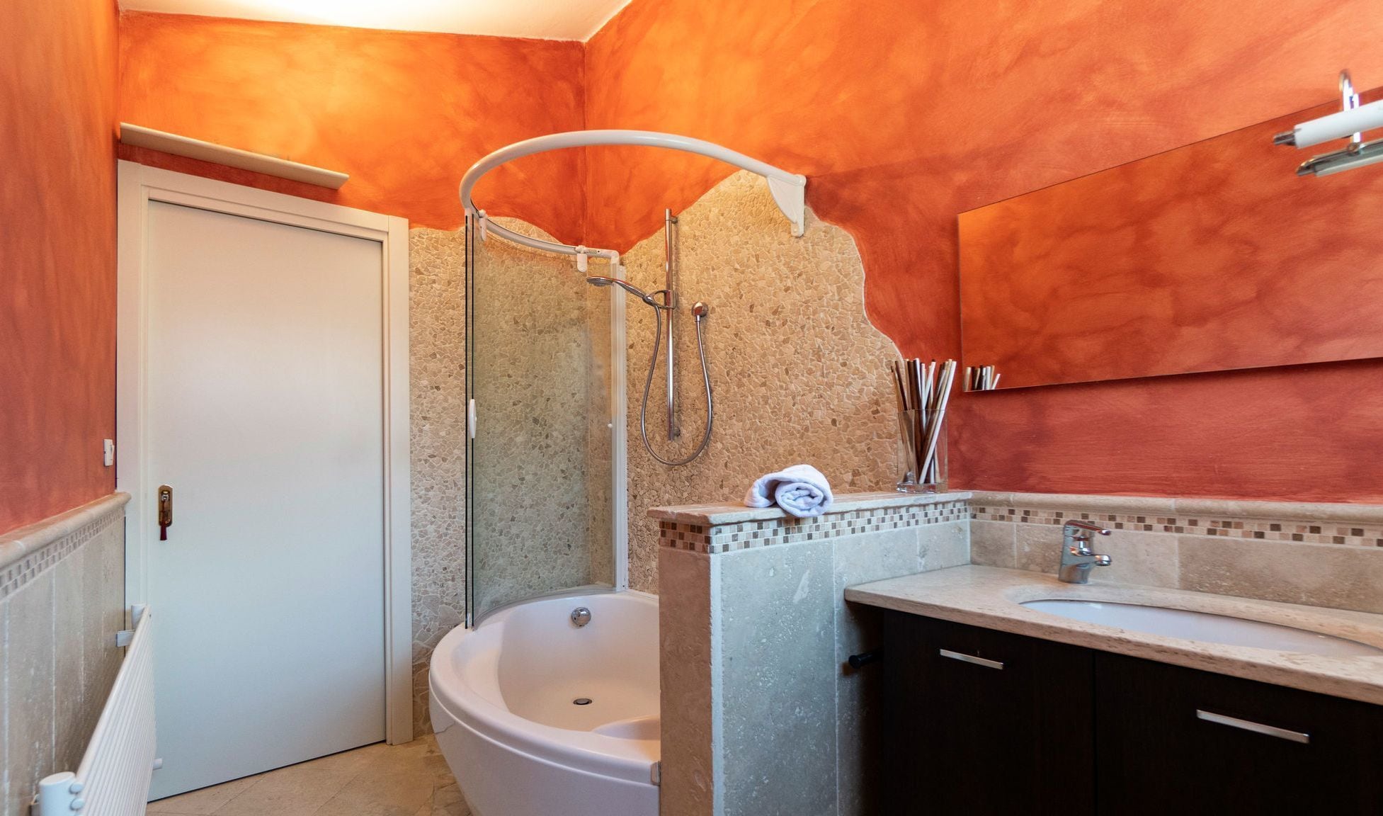 A bathroom with a bathtub, a shower, a sink, and a mirror.