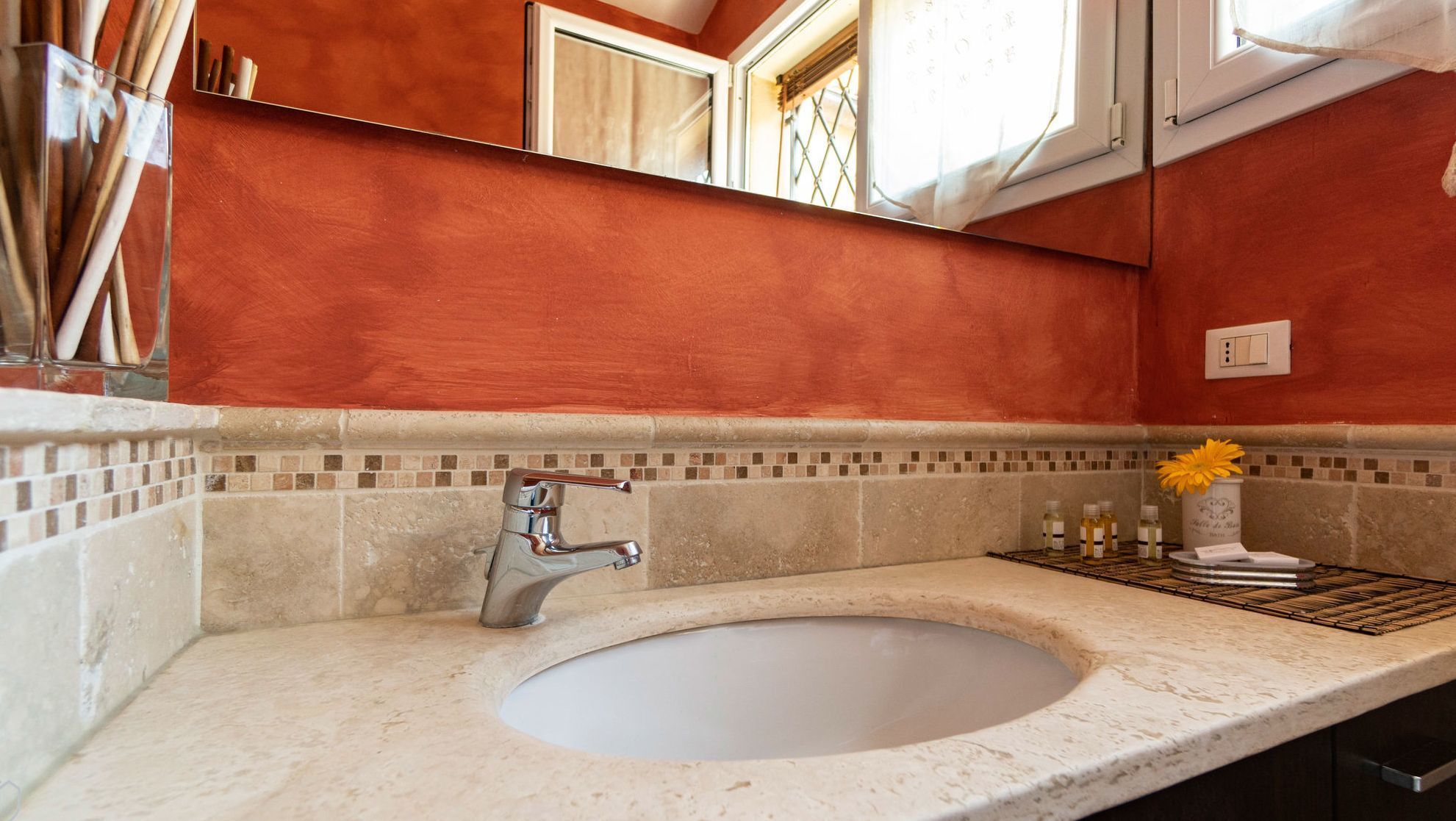 Un baño con un lavamanos grande, un espejo y una ventana con vistas al exterior.