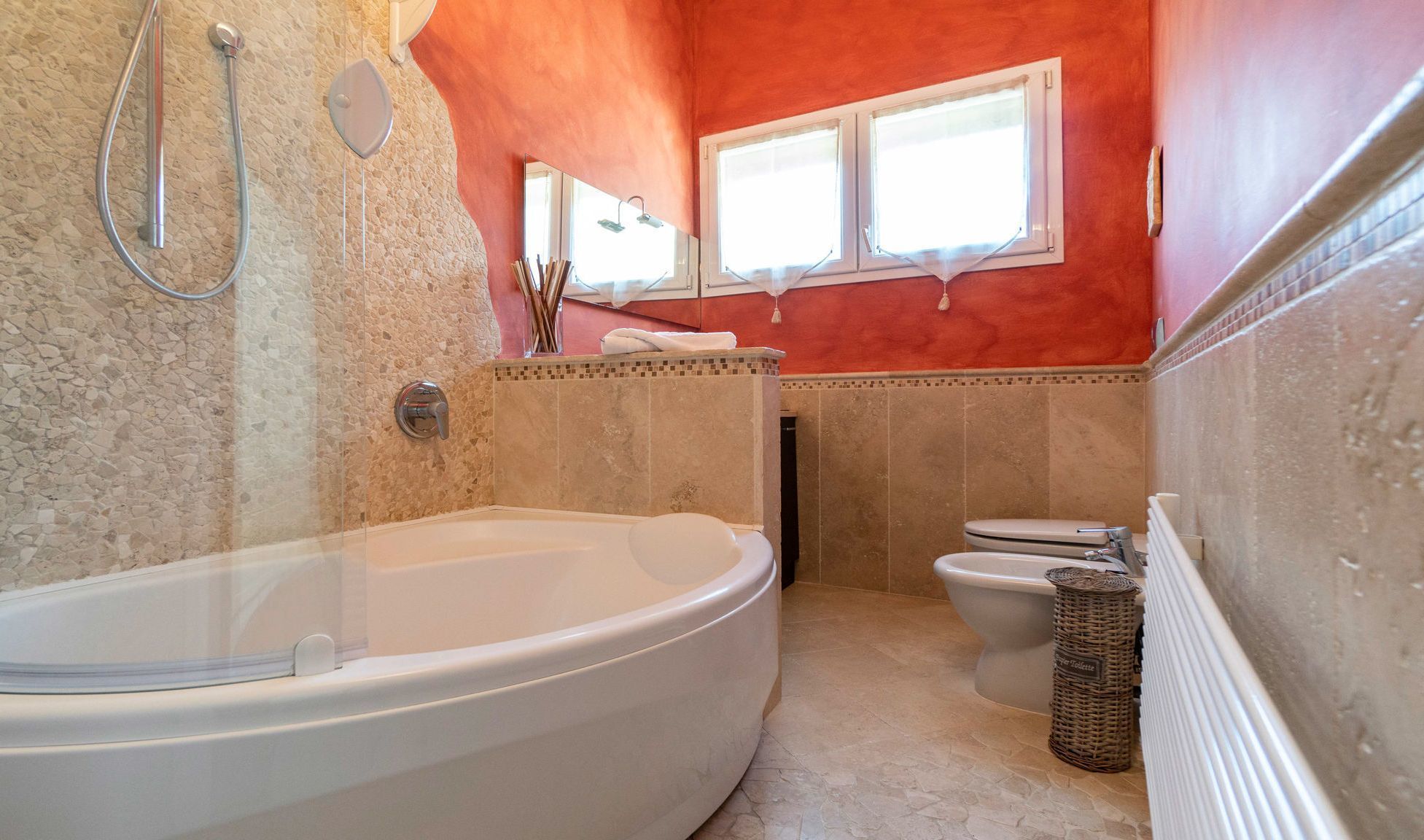 Un baño con bañera independiente, inodoro y zona de ducha.