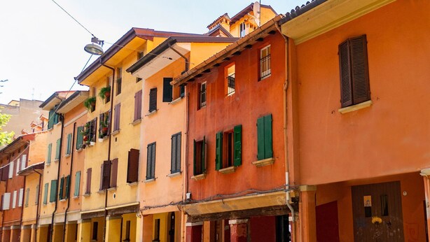 Une rangée de bâtiments colorés, dotés de balcons et de volets.