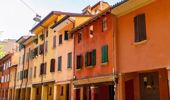 A row of colorful buildings with balconies and shutters.