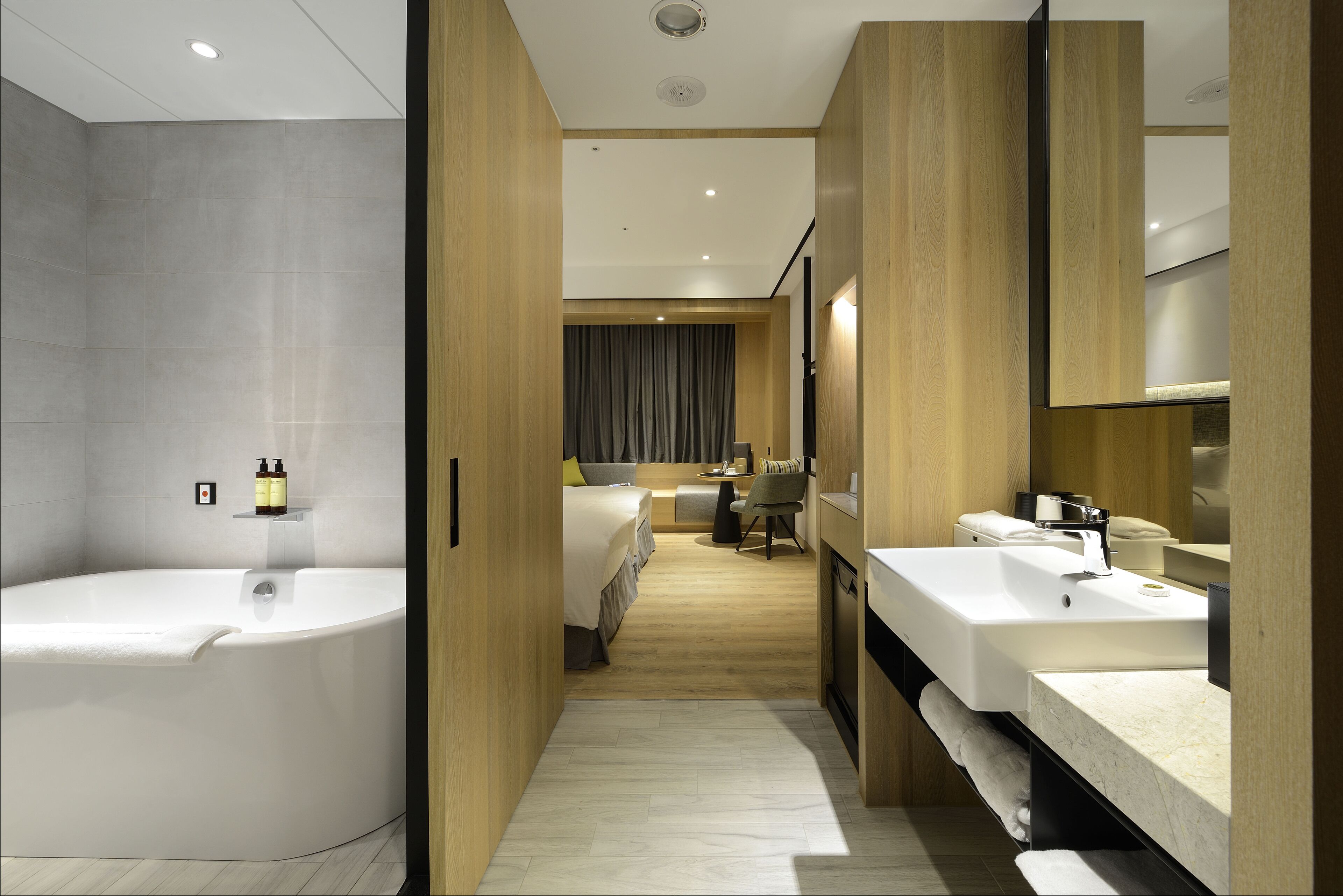 A modern bathroom with a large bathtub, a vanity with a mirror, and a shower area.