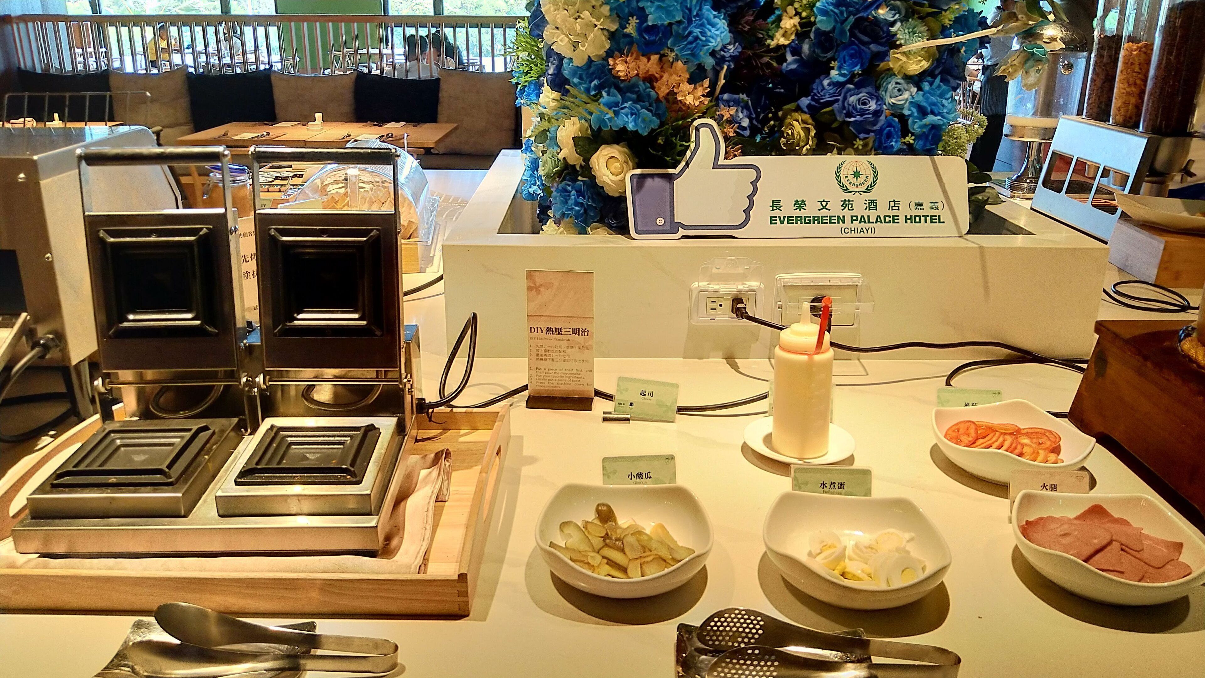 A buffet setup with various food items and a coffee machine.