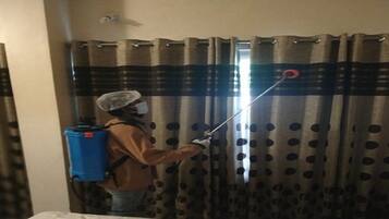 Una persona usando un rociador en cortinas.