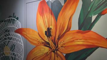 A large, vibrant orange flower mural on a wall.
