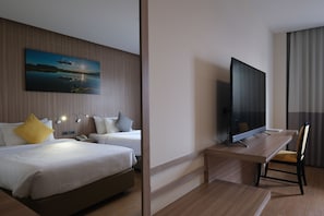 A hotel room with two beds, a flat-screen TV, a desk, and a chair. - Le Cassia Hotel (Khon Kaen)